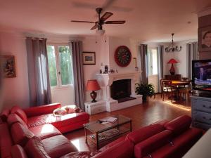 a living room with red couches and a fireplace at Les coquelicots in Villeneuve-sur-Lot