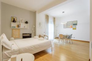a white bedroom with a bed and a dining room at Yourbanflat Porta Altinate in Padova +26 photos