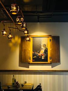 a kitchen with a painting on the wall and lights at Hotel AK International - Chennai in Chennai +21 photos