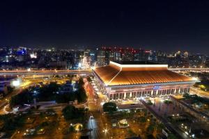 a large building with lights in a city at night at Sky19 Hotel in Taipei +57 photos