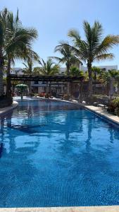 ein großer blauer Pool mit Palmen im Hintergrund in der Unterkunft CASA DE PLAYA in Isla de Redo