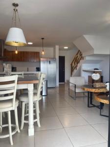 eine Küche und ein Wohnzimmer mit Tisch und Stühlen in der Unterkunft CASA DE PLAYA in Isla de Redo