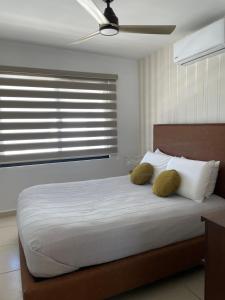 ein Schlafzimmer mit einem Bett mit zwei gelben Kissen in der Unterkunft CASA DE PLAYA in Isla de Redo