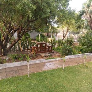 una mesa de picnic en un jardín con árboles y césped en Linga Longa, en Beaufort West