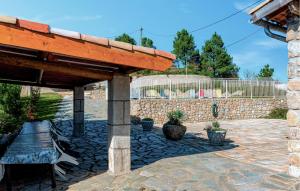 a pavilion with a bench and a stone wall at Bastide Les Chataigners in Pont-de-Labeaume +20 photos