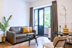 a living room with a couch and a table at Stylish Studio with Balcony, Near Tilburg Station in Tilburg