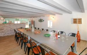 a dining room with a long table and chairs at Bastide Les Chataigners in Pont-de-Labeaume
