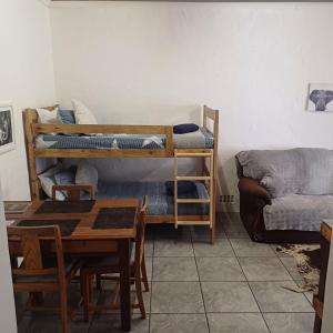Habitación con literas, mesa y sofá. en Linga Longa, en Beaufort West