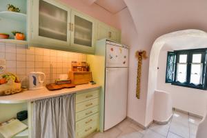 Una cocina con un refrigerador blanco y un fregadero. en Christos Apartments Oia, en Oia