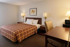 a hotel room with a bed and a desk at Key Inn Roseville in Roseville