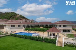 ロナバラにあるStayVista at Sicily with Pool and Wi-Fiのスイミングプールと芝生のあるヴィラ