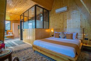 比姆塔尔Echo By The Lakes Pet-friendly Retreat by the Lake With Game Zone & Garden的一间带一张大床的卧室,位于带木墙的房间 更多37张照片