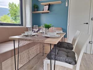 AltossiachMobilhome-Bali Premium by Camping Lampele-Ossiachersee-Klimaanlage-Radfahren-Wandern-Auszeit的用餐室配有桌椅和酒杯