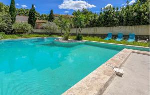 a swimming pool with blue chairs in a yard at Maison Piscine Proche Arles in Tarascon +23 photos