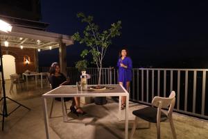two women standing on a balcony at night at Earthbound Residence- Kandy in Kandy