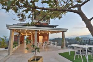 a house with a deck with a table and chairs at Earthbound Residence in Kandy