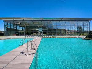 a large swimming pool in front of a building at Holiday Park La Sapinière in Hosingen