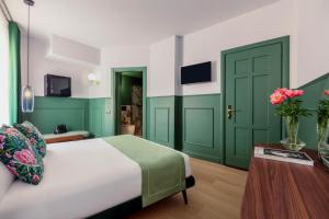 una camera da letto con porte verdi, un letto e un tavolo di Hotel Concordia a Roma