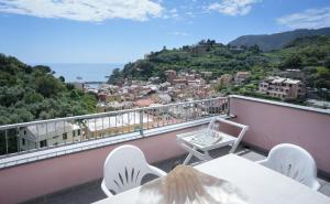 a balcony with tables and chairs and a view of a city at Blue Horizon Apartment- 5 Terre in Monterosso al Mare