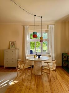 a dining room table with chairs and a window at Ferienapartment Janow in Spantekow