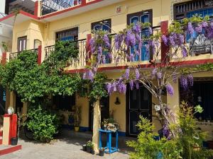 a building with purple flowers on the balconies at Katyuri Kings Divine Stay- Babaji's cave in Dwārāhāt