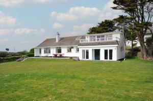 a large white house with a large yard at Dolphins in Polzeath