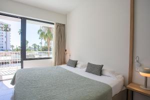 a bedroom with a bed and a large window at Villa Miel in Cala Millor