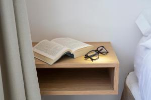 a book and glasses on a table next to a bed at Villa Miel in Cala Millor