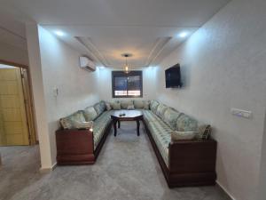 a living room with a couch and a table at Saïdia Residence A - Plage accessible à pied in Saïdia
