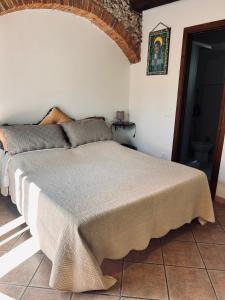 a bed in a white room with a bedspread at Spirito del mare in Portoferraio