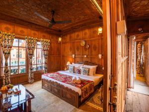 a bedroom with a bed in a room with wooden walls at Moustache Houseboat Srinagar in Srinagar