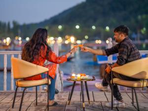a man and woman sitting around a table with candles at Moustache Houseboat Srinagar in Srinagar