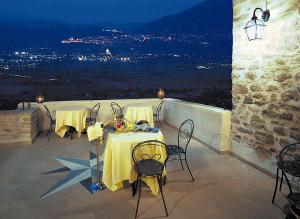 Ein Tisch und Stühle auf einer Terrasse bei Nacht in der Unterkunft Relais La Corte di Bettona in Bettona