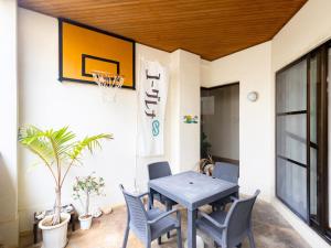 une salle à manger avec une table, des chaises et un panier de basket dans l'établissement 石垣島グループの宿 2216 にじいろ ユーグレナモール内, à Ishigaki