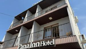 a building with balconies and a sign in front of it at Pana Inn in Almaty