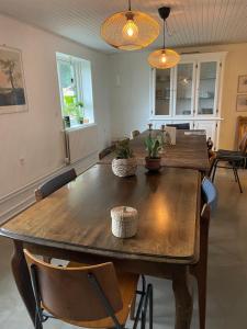 a dining room with a large wooden table and chairs at Holmely Bed & Breakfast in Brædstrup