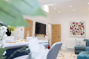 a living room with a table and a blue couch at A spacious and modern 4Bedroom house in Borehamwood
