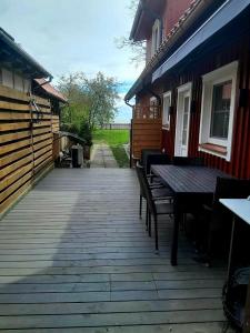 a wooden patio with a table and chairs on it at Prie mariu in Nida