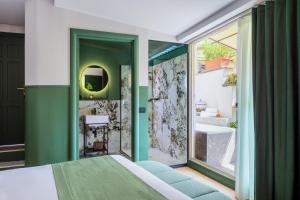 una camera da letto con una parete verde e un bagno con lavandino di Hotel Concordia a Roma