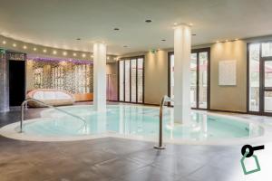 a hot tub in the middle of a room with windows at Hotiday Marina di Bibbona in Marina di Bibbona