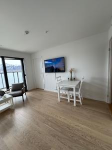 a living room with a white table and chairs at Wonderful apartment in centrum in Tromsø