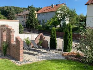 a garden with two chairs and a brick wall at Ferienhaus Staudensonne in Langenneufnach