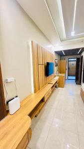 Una habitación con un banco de madera con un televisor encima. en Snooze and Stay Omaxe Hazratganj, en Lucknow