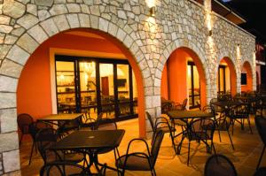 a group of tables and chairs in a restaurant at Vytina Mountain View Hotel in Vitina