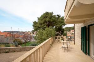 a balcony with a table and chairs on a fence at Sun Spalato Maslinica in Maslinica
