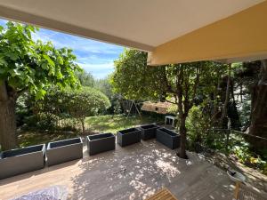 a patio with chairs and a tree in a yard at Villa le Cap - Apartement in Roquebrune-Cap-Martin