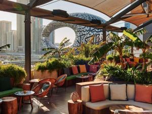 a patio with tables and chairs and a view of a city at 25hours Hotel Dubai One Central in Dubai