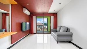 a living room with a couch and a tv at Geojedo Pilos Ocean View Pension in Geoje 