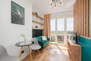 a living room with a green couch and a table at Piotrkowska Sunset Apartment in Łódź
