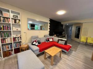 a living room with a couch and a red blanket at Couleurs de la vie - Chambres d'Hôtes et Gîte in Cormatin